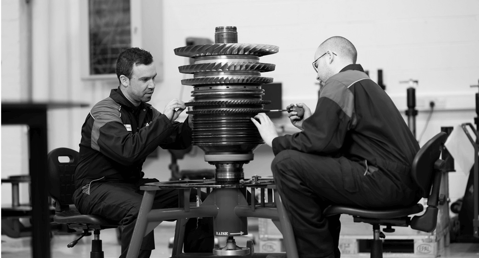 Two technicians working on an engine