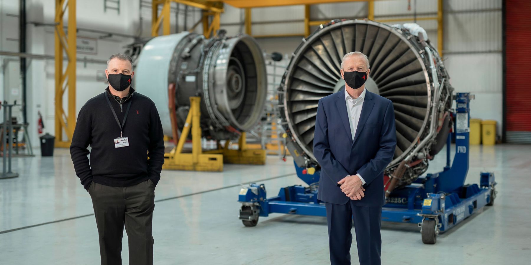 Aerfin staff standing in front of airplane engines in their HQ 